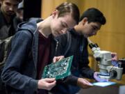 Cody Wold, senior at Evergreen High School, checks out circuit boards at the Silicon Forest Electronics booth during Manufacturing Day at Clark College on Tuesday.