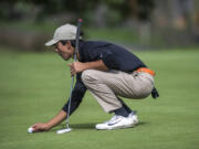 Battle Ground’s Anthony Tobias places his ball before putting during the 4A district boys golf tournament at Tri-Mountain Golf Course on Tuesday.