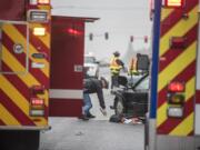 A state patrol trooper marks the ground at the scene of an accident on state Highway 500 on Monday afternoon.