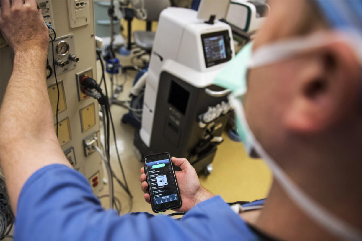 Dr. Benjamin Jacobs selects his Spotify playlist before a carpal tunnel surgery at PeaceHealth Southwest Medical Center. According to a Spotify and Figure 1 survey, 90 percent of nearly 700 surgeons and other health care professionals said they listen to music during operations.