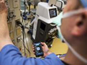 Dr. Benjamin Jacobs selects his Spotify playlist before a carpal tunnel surgery at PeaceHealth Southwest Medical Center. According to a Spotify and Figure 1 survey, 90 percent of nearly 700 surgeons and other health care professionals said they listen to music during operations.