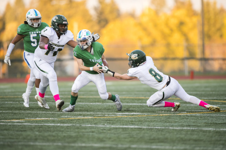 Evergreen defenders sack Mountain View's Garrett Moen at McKenzie Stadium on Thursday night, Oct. 11, 2018.