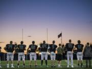 Woodland players listen to the national anthem before their game against Ridgefield at Woodland High School on Friday night, Oct. 12, 2018.