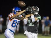 A Ridgefield defender tries and fails to breakup a pass to Woodland's Wyatt Wooden during a game at Woodland High School on Friday night, Oct. 12, 2018.