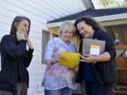 Homeowner Alice Jull of Vanport Rigging, center, receives documents during a follow-up visit from Matrix Roofing CEO Wendy Marvin, right, and her assistant Rhianna Phillips, after the completion of the roofing job on Jull’s home in Salmon Creek earlier this month.