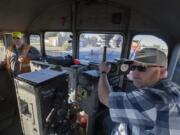 Anthony Hauzenberger, right, of Portland Vancouver Junction Railroad, works with general manager Nathan Bruce as he sounds the horn while traveling over a railroad crossing at Rye rail yard in Vancouver on Wednesday morning.