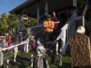 Dawn and Frank Lott are pictured outside their home in Camas. The couple were married over the summer and created “his” and “hers” sides of the lawn for Halloween. Dawn Lott’s side features scary clowns, and Frank Lott’s side features a homemade coffin and tombstones.