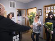 Benno Dobbe, owner of Woodland’s Holland America Flower Gardens, from left, hands flowers to Kim Hulett, Lois Hulett and Shari Hartshorn of Woodland Insurance Agency during Wednesday’s Petal It Forward. Holland America was one of more than 450 participants in the nationwide event, where florists go out and give away free flowers.