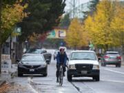 A cyclist navigates through traffic on Columbia Street near the intersection with West Sixth Street, while at left in the background a car blocks the bike lane. Via the Westside Bike Mobility Project, the city is designing north-south bike routes to enable riders of varying abilities to ride between downtown Vancouver and the city’s other west-side neighborhoods.