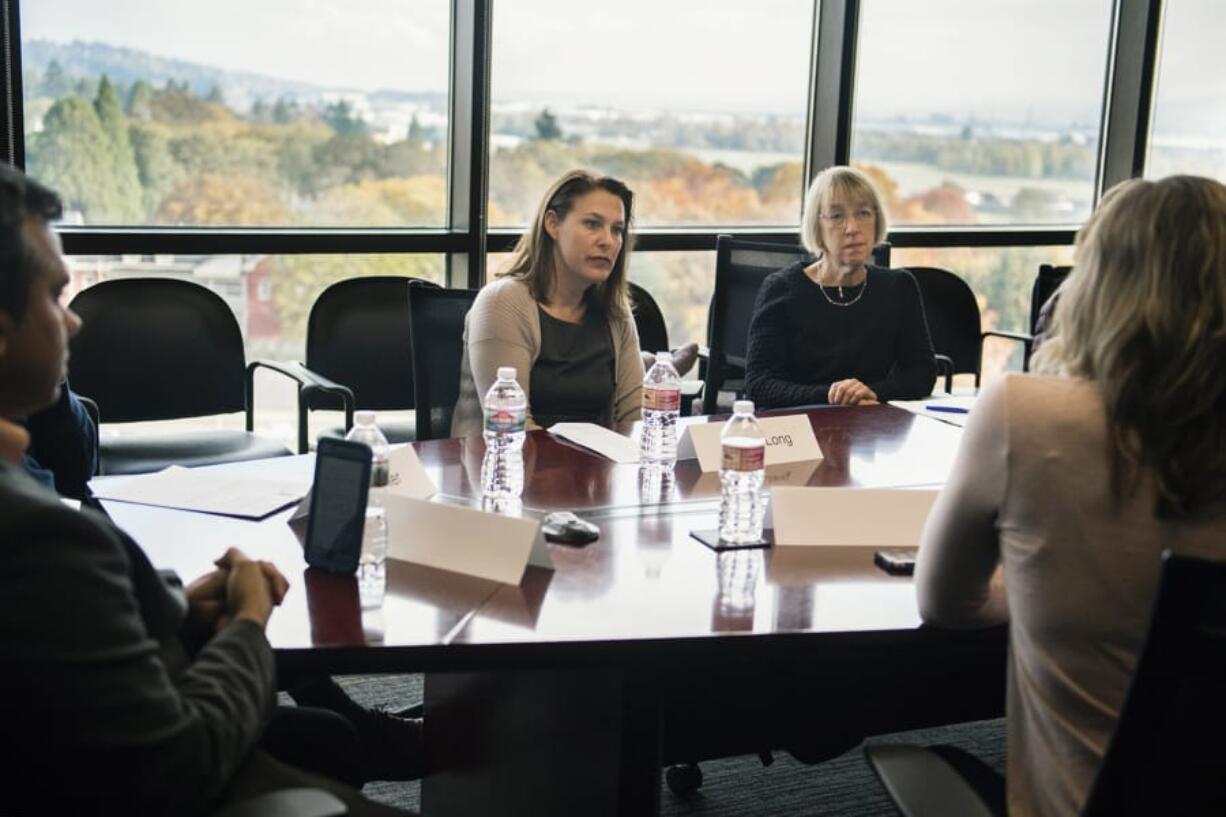 Carolyn Long, Democratic candidate for the 3rd Congressional District, center left, and Sen. Patty Murray, D-Wash, listen to attendees during a roundtable discussion on health care in the DiscoverOrg conference room on Tuesday. Long said she hopes to replicate Murray’s bipartisan work on health care if elected to the House.