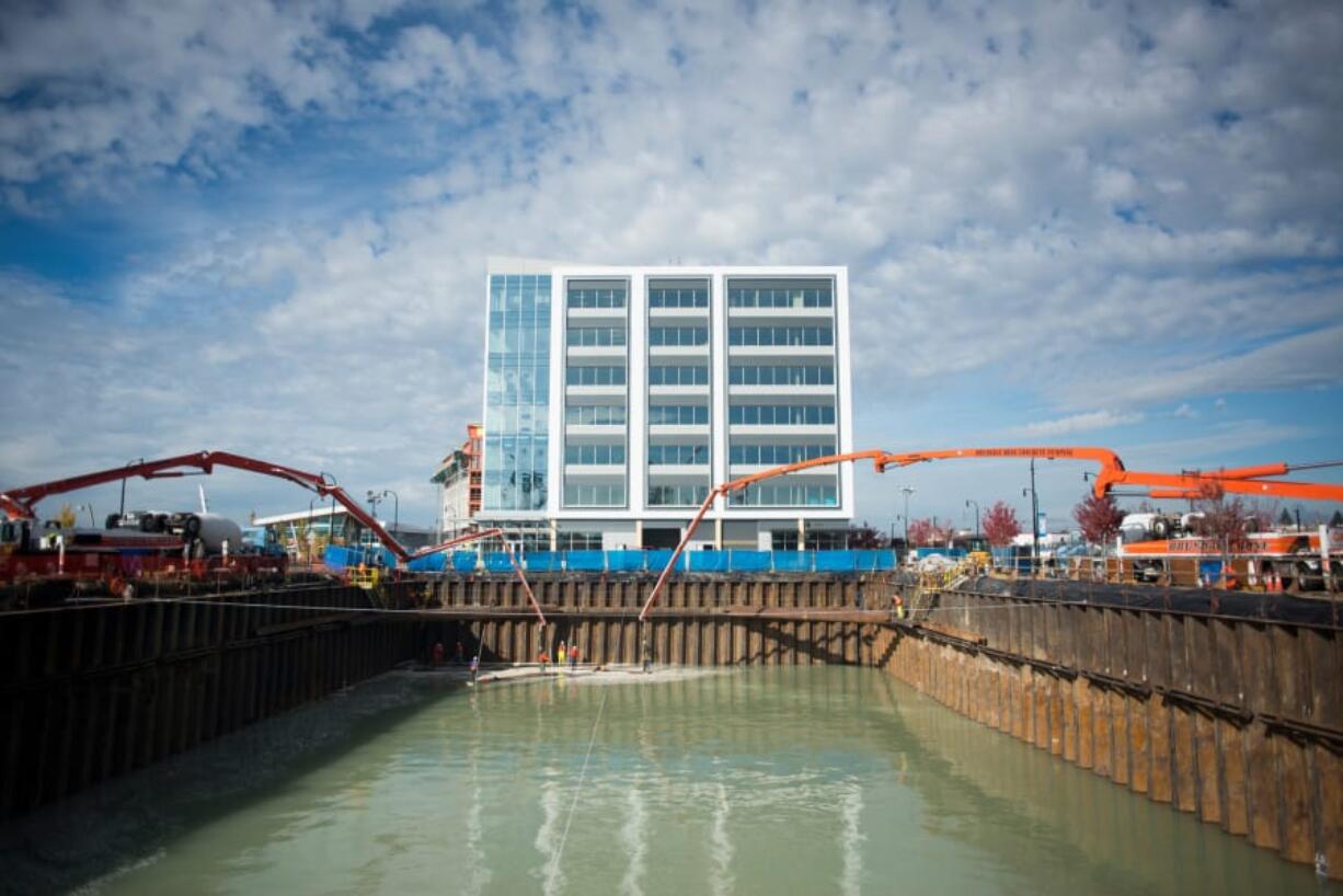 Concrete boom arms pump 5 feet of concrete underneath 8 feet of groundwater in a cofferdam that will form the foundation of the future Hotel Indigo at The Waterfront Vancouver. The water, an intrusion from the Columbia River, will be pumped out later, perhaps this week.