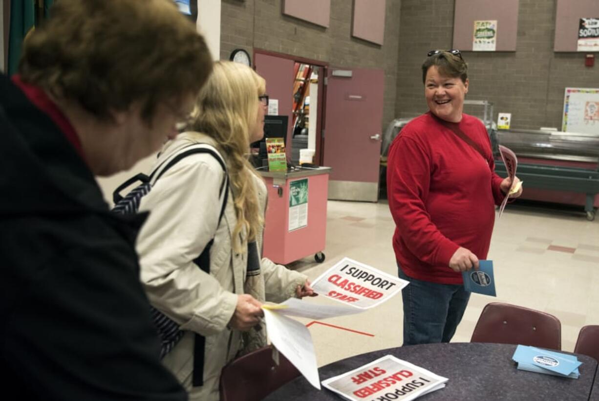 Terri Sadowski, left, and Merritt Hitzeman-Anzjon, right, both paraeducators at Hudson's Bay High School, pick up signs reading, “I Support Classified Staff," before a Vancouver Association of Educational Support Professionals general membership meeting at Roosevelt Elementary School in Vancouver on Tuesday. Vancouver Public Schools announced it was requesting guidance from professional mediators in negotiations with the union.