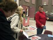 Terri Sadowski, left, and Merritt Hitzeman-Anzjon, right, both paraeducators at Hudson's Bay High School, pick up signs reading, “I Support Classified Staff," before a Vancouver Association of Educational Support Professionals general membership meeting at Roosevelt Elementary School in Vancouver on Tuesday. Vancouver Public Schools announced it was requesting guidance from professional mediators in negotiations with the union.