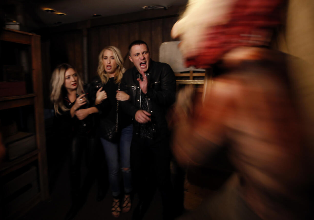 Actors Billie Lourd, left, Leslie Grossman, middle, and Colton Haynes, right, members of the cast of FX’s “American Horror Story” get spooked Sept. 22, 2017, while going through a Halloween-themed maze at Universal Studios.