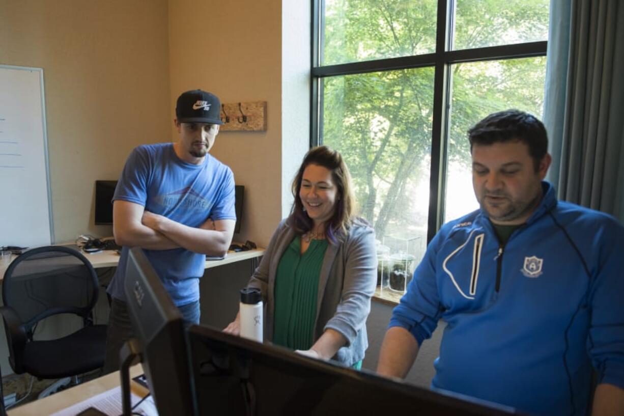 Hubb senior account executive Steven Williams, from left, president and CEO Allie Magyar and vice president of sales Brian Gaffney discuss new business proposals at the Hubb offices in Vancouver in May.