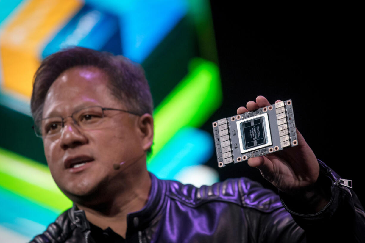 Jensen Huang, president and chief executive officer of Nvidia Corp., holds a Nvidia Volta 125 Teraflops per second Tensor Core as he speaks during an event at the 2018 Consumer Electronics Show in Las Vegas on Jan. 7.