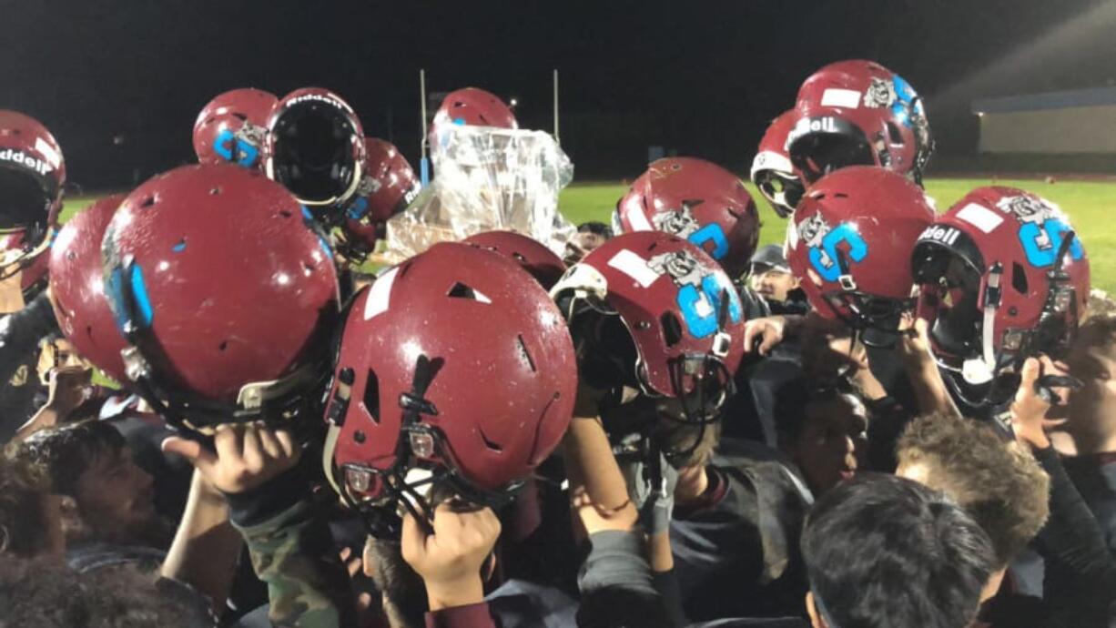 Stevenson players hoist the “Gorge Bowl” trophy, covered in plastic wrap to protect it from rain, after Friday’s victory over Columbia-White Salmon.