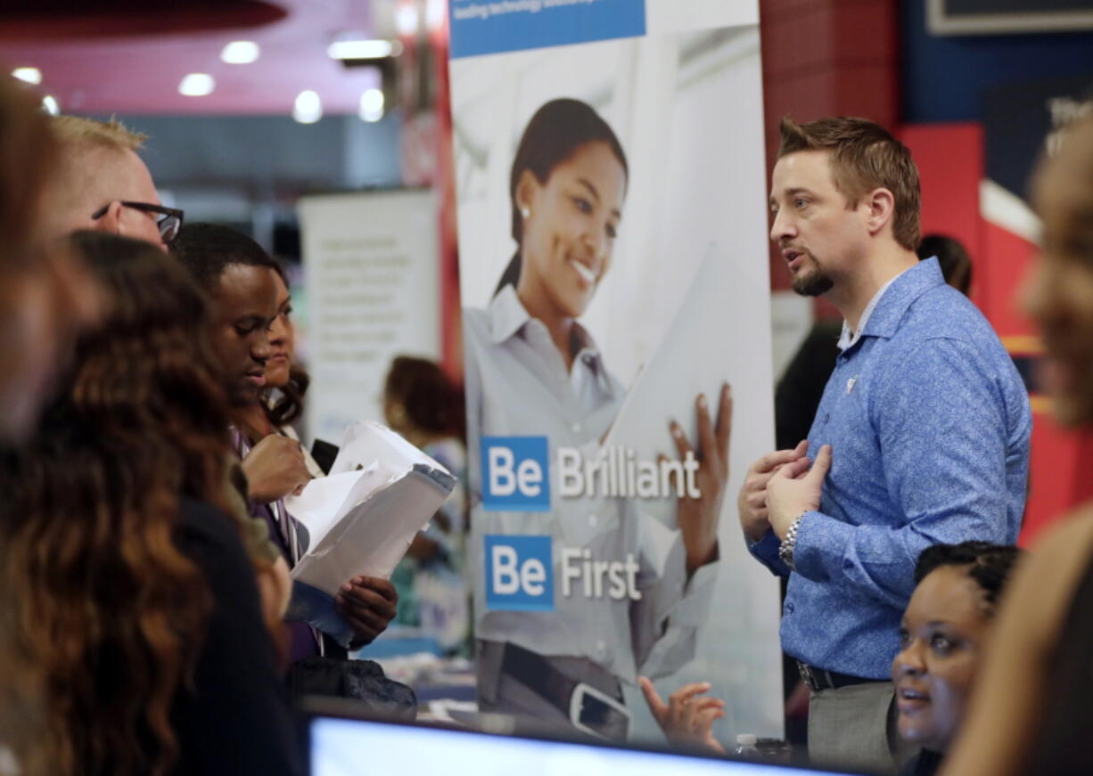 FILE- In this June 21, 2018, file photo, Chad Beutler, of First Data, right, talks with applicants at a job fair hosted by Job News South Florida, in Sunrise, Fla. On Wednesday, Oct. 3, the payroll processor ADP reports how many jobs private employers added in September.