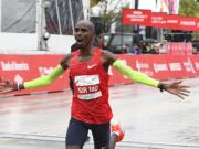 Mo Farah, of Britain, raises his arms after finishing in first place during the Bank of America Chicago Marathon, Sunday, Oct. 7, 2018, in Chicago.