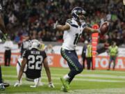 Seattle Seahawks wide receiver Tyler Lockett (16) celebrates after scoring a touchdown during the second half of an NFL football game against Oakland Raiders at Wembley stadium in London, Sunday, Oct. 14, 2018.