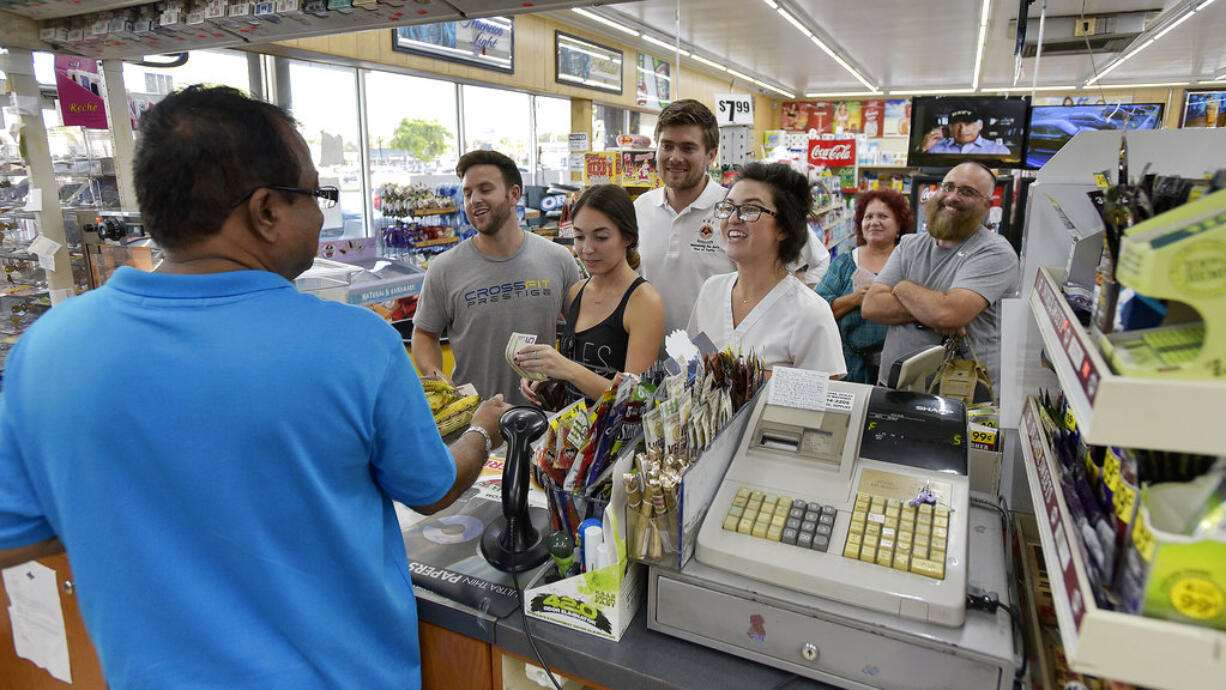 People line up at the Kwik Stop food store at 46th Avenue and Hollywood Boulevard, in Hollywood, Fla., to buy Mega Millions lottery tickets, Friday, Oct. 19, 2018.