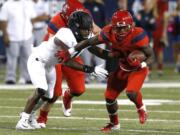 Arizona running back J.J. Taylor (21) stiff arms an Oregon defender in the first half during an NCAA college football game, Saturday, Oct. 27, 2018, in Tucson, Ariz.