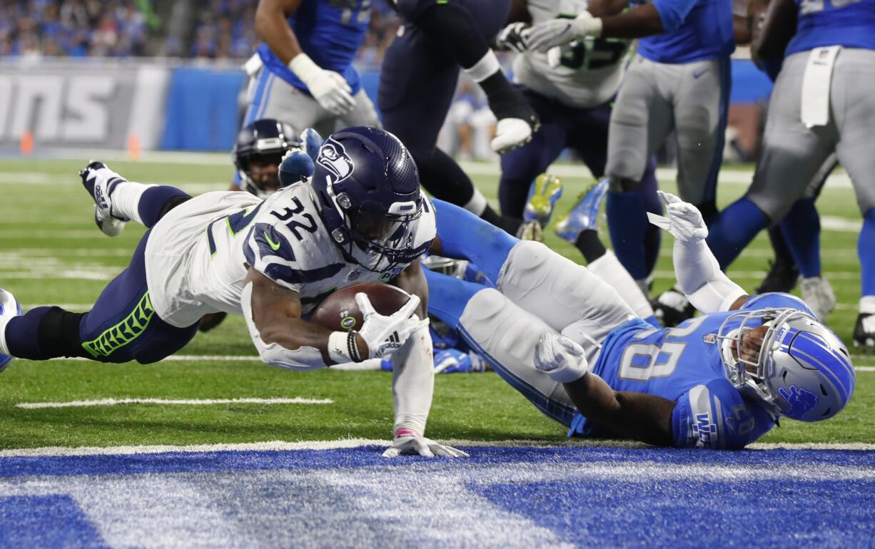 Seattle Seahawks running back Chris Carson (32) dives into the end zone for a 7-yard touchdown rush during the second half of an NFL football game against the Detroit Lions, Sunday, Oct. 28, 2018, in Detroit.