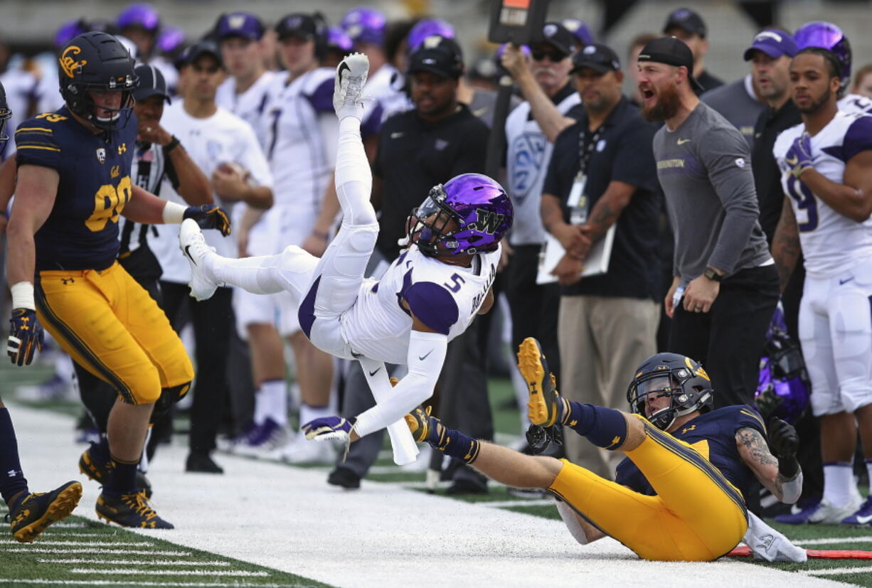 Washington’s Andre Baccellia (5) is upended by California’s Ashtyn Davis, right, during the first half of an NCAA college football game Saturday, Oct. 27, 2018, in Berkeley, Calif.