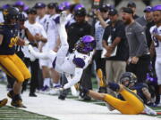 Washington’s Andre Baccellia (5) is upended by California’s Ashtyn Davis, right, during the first half of an NCAA college football game Saturday, Oct. 27, 2018, in Berkeley, Calif.