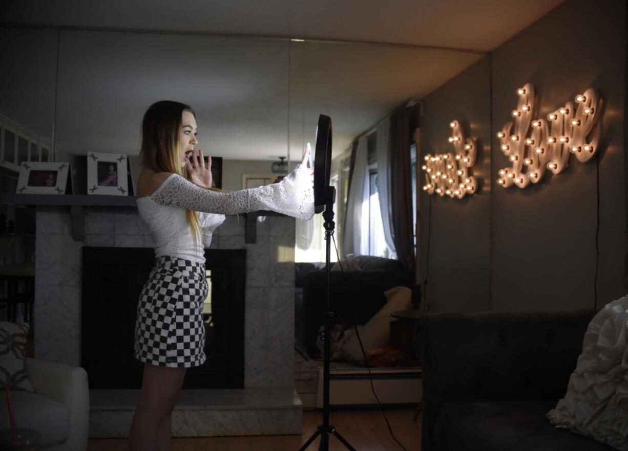 Matty Nev Luby holds up her phone in front of a ring light she uses to lip-sync with the smartphone app Musical.ly, in Wethersfield, Conn. Teens and young adults say cyberbullying is a serious problem for people their age, but most don’t think they’ll be the ones targeted for digital abuse. That’s according to a new poll from The Associated Press-NORC Center for Public Affairs Research and MTV. The poll also finds that about half of both young people and their parents view social media as having a mostly negative effect on the younger generation.