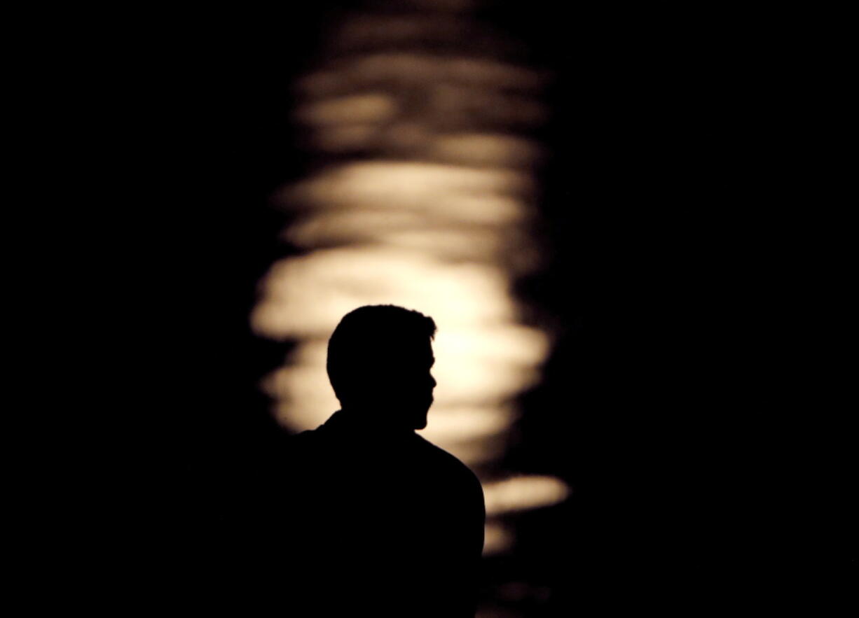 A man is silhouetted against moonlight reflecting off the Missouri River as he watches the full moon rise beyond downtown buildings in Kansas City, Mo. A by the Associated Press-NORC Center for Public Affairs Research and MTV found that half of 15 to 26-year olds think they will eventually be better off than their parents in terms of household finances. About 29 percent expect to do as well as their parents and 20 percent expect to be worse off.