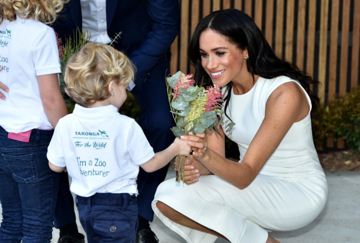 Meghan the Duchess of Sussex receives native flowers from 4-year-old Findlay Blue after she and Prince Harry officially opened the Taronga Institute of Science and Learning at Taronga Zoo in Sydney, Australia, Tuesday, Oct. 16, 2018.