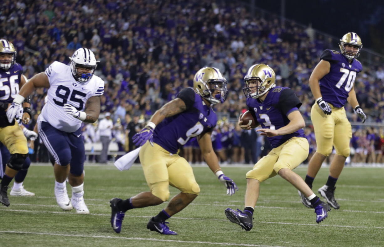 Washington quarterback Jake Browning (3) scrambles for a touchdown as offensive lineman Jared Hilbers (70) looks on during the first half of an NCAA college football game against Brigham Young, Saturday, Sept. 29, 2018, in Seattle. (AP Photo/Ted S.