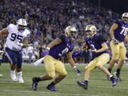 Washington quarterback Jake Browning (3) scrambles for a touchdown as offensive lineman Jared Hilbers (70) looks on during the first half of an NCAA college football game against Brigham Young, Saturday, Sept. 29, 2018, in Seattle. (AP Photo/Ted S.