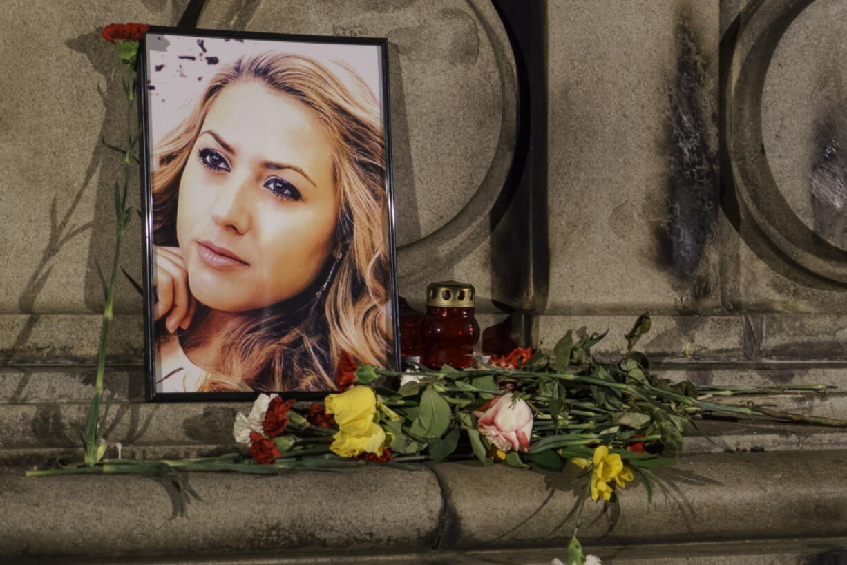 A portrait of slain television reporter Viktoria Marinova is placed next to flowers and candles at a vigil Tuesday in Ruse, Bulgaria. Her body was found Saturday after she reported on the possible misuse of European Union funds in Bulgaria.