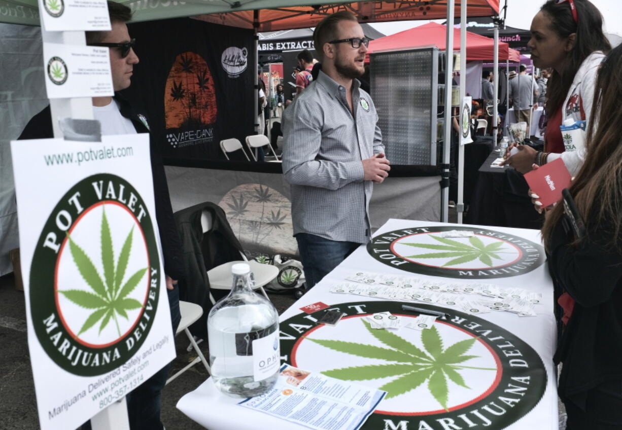 FILE - This March 31, 2018 photo shows a booth advertising a delivery service for cannabis at the Four Twenty Games in Santa Monica, Calif. California is moving a step closer to allowing marijuana deliveries in communities that have banned retail sales. Regulators on Friday, Oct. 19, 2018, announced preliminary approval of the proposed rule over objections from cities and police chiefs who say the policy will lead to crime.