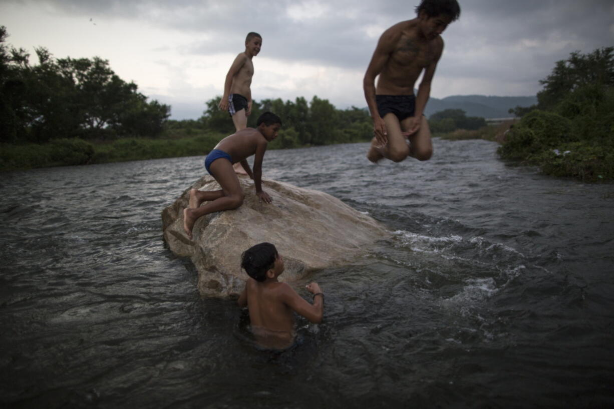 Honduran migrants have fun after having a bath in a river in Pijijiapan, Mexico, on Thursday. Thousands of Central American migrants renewed their hoped-for march to the United States on Wednesday, setting out before dawn with plans to travel another 45 miles (75 kilometers) of the more than 1,000 miles that still lie before them.