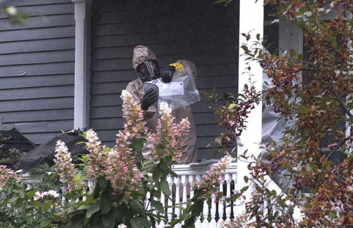 A person in a hazmat suit appears to be handling a letter that is enclosed in a plastic bag in Bangor, Maine, Monday, Oct. 15, 2018. A hazardous materials team was called Monday to investigate a suspicious letter sent to the home of Republican Sen. Susan Collins, officials said. Law enforcement officials were analyzing the contents of the letter. An FBI spokeswoman said Monday evening that preliminary tests on the envelope indicated there was no threat to the public.