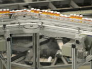 Bottles of medication travel along on a belt at the Express Scripts mail-in pharmacy warehouse in Florence, N.J.