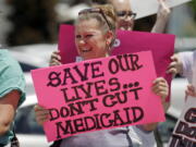 FILE - In this June 27, 2017 file photo, protesters block a street during a demonstration against the Republican bill in the U.S. Senate to replace former President Barack Obama’s health care law, in Salt Lake City.