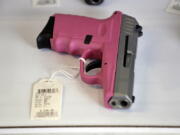 A pistol sits in a display case at a gun shop in Lynnwood. Washington’s Initiative 1639 would require safe storage of all firearms and tougher background checks for buyers of semi-automatic rifles.