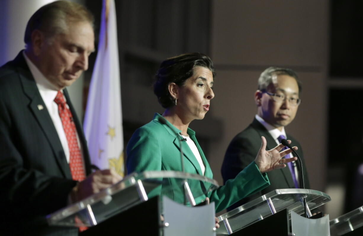 FILE - In this Thursday, Sept. 27, 2018 file photo, Rhode Island gubernatorial candidates, former state Rep. Joseph Trillo, who is running as an independent, left, Democratic Gov. Gina Raimondo, center, and Republican Cranston Mayor Allan Fung, right, participate in a debate in Bristol, R.I. Inspired by how the GI Bill helped her father become the first in his family to go to college, Raimondo unveiled a plan in 2017 to offer free tuition at the state’s three public colleges. The Legislature, despite being dominated by Raimondo’s fellow Democrats, was reluctant to support it, citing the cost. The governor ended up with a pilot program at just one of the colleges.