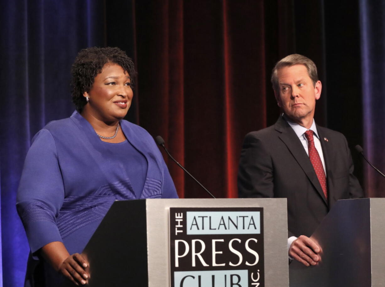 Democratic gubernatorial candidate for Georgia Stacey Abrams, left, speaks as her Republican opponent Secretary of State Brian Kemp looks on during a debate Tuesday in Atlanta.