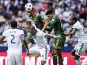 Portland Timbers' Bill Tuiloma, back left, gets his head on the ball in front of teammate Julio Cascante, second from right, as Vancouver Whitecaps' Kendall Waston (4), Ali Ghazal (66) and Doneil Henry (2) defend during the first half of an MLS soccer game in Vancouver, British Columbia, Sunday, Oct. 28, 2018.