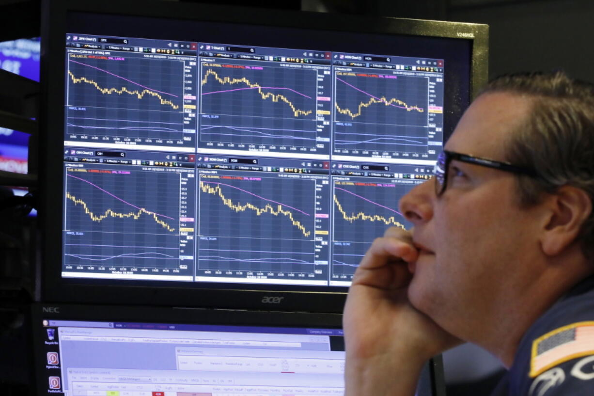 FILE- In this Oct. 10, 2018, file photo specialist Gregg Maloney works at his post on the floor of the New York Stock Exchange. The stock market has offered the best long-term returns historically, but they’ve come at a price. Stocks can drop suddenly, sometimes for inexplicable reasons. Drops of 10 percent are common enough, even when the market is largely on the upswing, that Wall Street has a term for them: “corrections.” Since the summer of 2015, the S&P 500 has had three such declines, and the index is one bad day away from a fourth. The S&P 500 is down TK percent since setting its record last month.