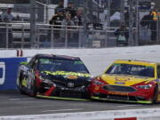 Joey Logano (22) and Martin Truex Jr. (78) make contact as they approach the finish line at the Monster Energy NASCAR Cup Series auto race at Martinsville Speedway in Martinsville, Va., Sunday, Oct. 28, 2018. Logano won the race.