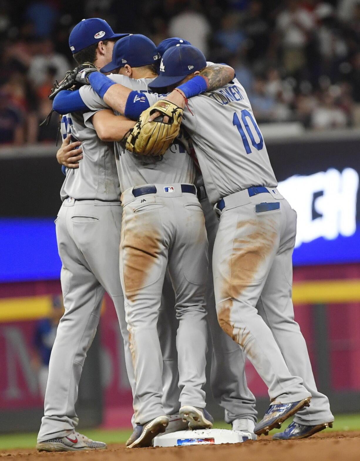 Los Angeles Dodgers team members embrace after Game 4 of baseball’s National League Division Series against the Atlanta Braves, Monday, Oct. 8, 2018, in Atlanta. The Los Angeles Dodgers won 6-2.