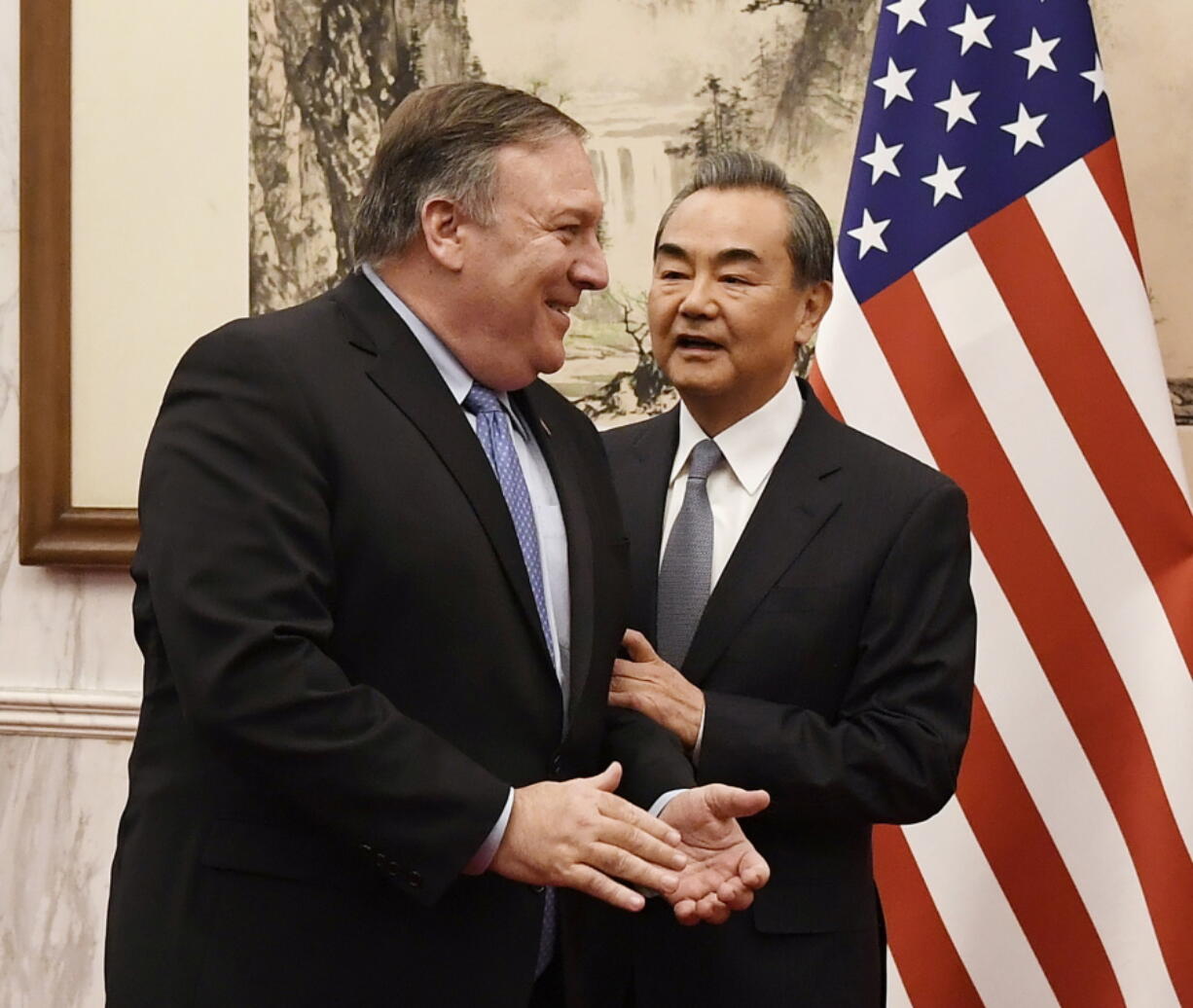 Chinese State Councilor and Foreign Minister Wang Yi, right, talks with U.S. Secretary of State Mike Pompeo, left, before a meeting at the Diaoyutai State Guesthouse in Beijing on Monday.