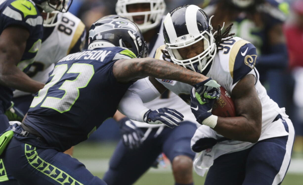 Los Angeles Rams running back Todd Gurley, right, powers past Seattle Seahawks free safety Tedric Thompson (33) to score a touchdown during the second half of an NFL football game, Sunday, Oct. 7, 2018, in Seattle.