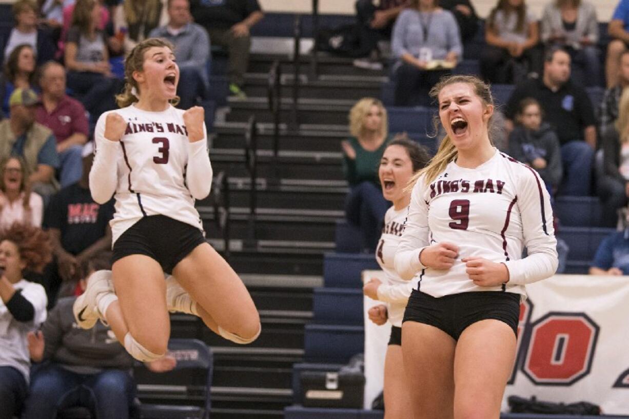 King's Way's Dana Snider (3), from left, Gracie Brown, and Abby Cummins celebrate a point in the first set against La Center at King's Way Christian School on Tuesday night, Oct. 2, 2018.